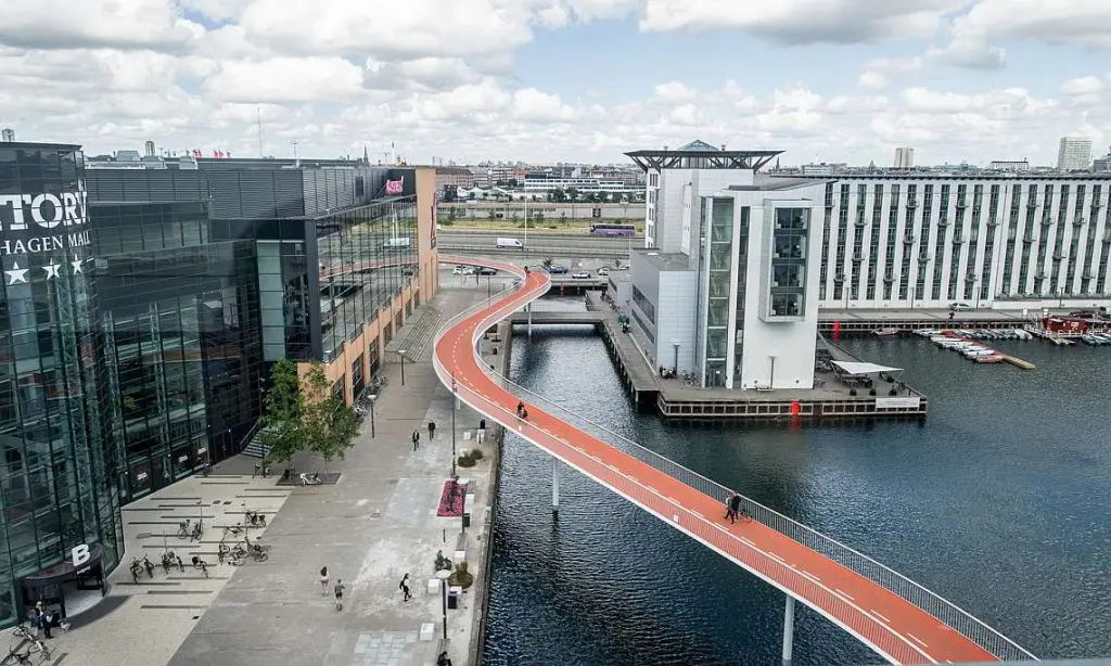 Behind Copenhagen’s bike-friendliness lies a consistent transport policy and urban planning. ‘Cykelslangen’ is a bridge through the Copenhagen harbor and is only open to cyclists. At night, the orange-colored floor lights up; © Credit: Cycling Embassy of Denmark, DISSING+WEITLING